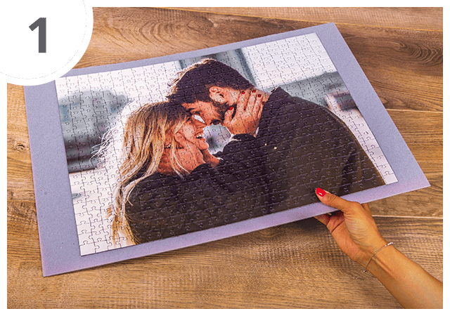 Coloca o puzzle fotográfico acabado sobre uma superfície estável e posiciona o vidro da moldura sobre a imagem.