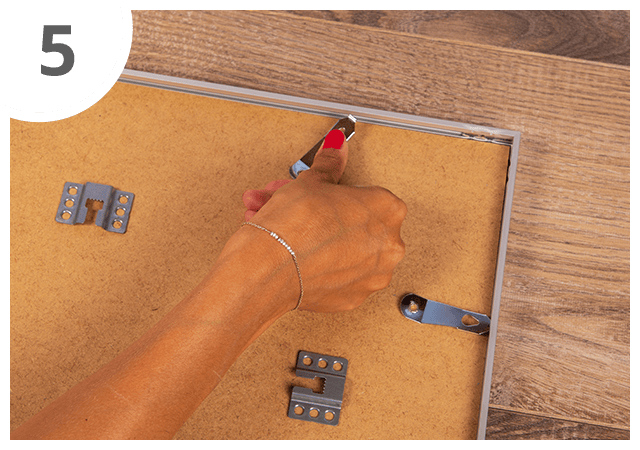 Para fixar, roda os fechos laterais para debaixo do perfil da moldura e encaixa-os.