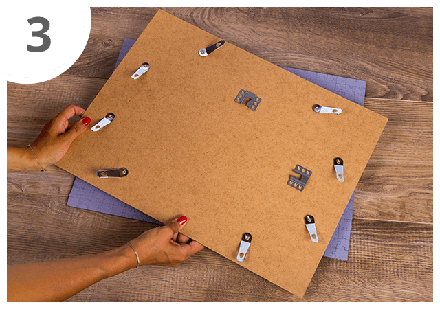 Coloca o fundo da moldura do puzzle sobre a parte de trás do puzzle, certificando-te de que está corretamente orientado, topo e base.
