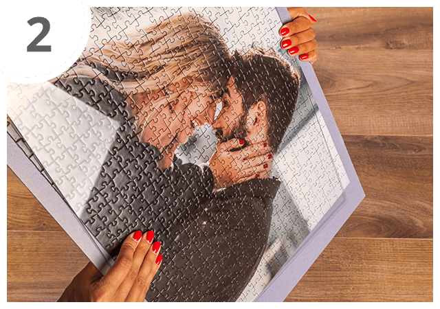 Vira o puzzle juntamente com o vidro, de modo que a parte de trás do cartão do puzzle fique virada para cima.